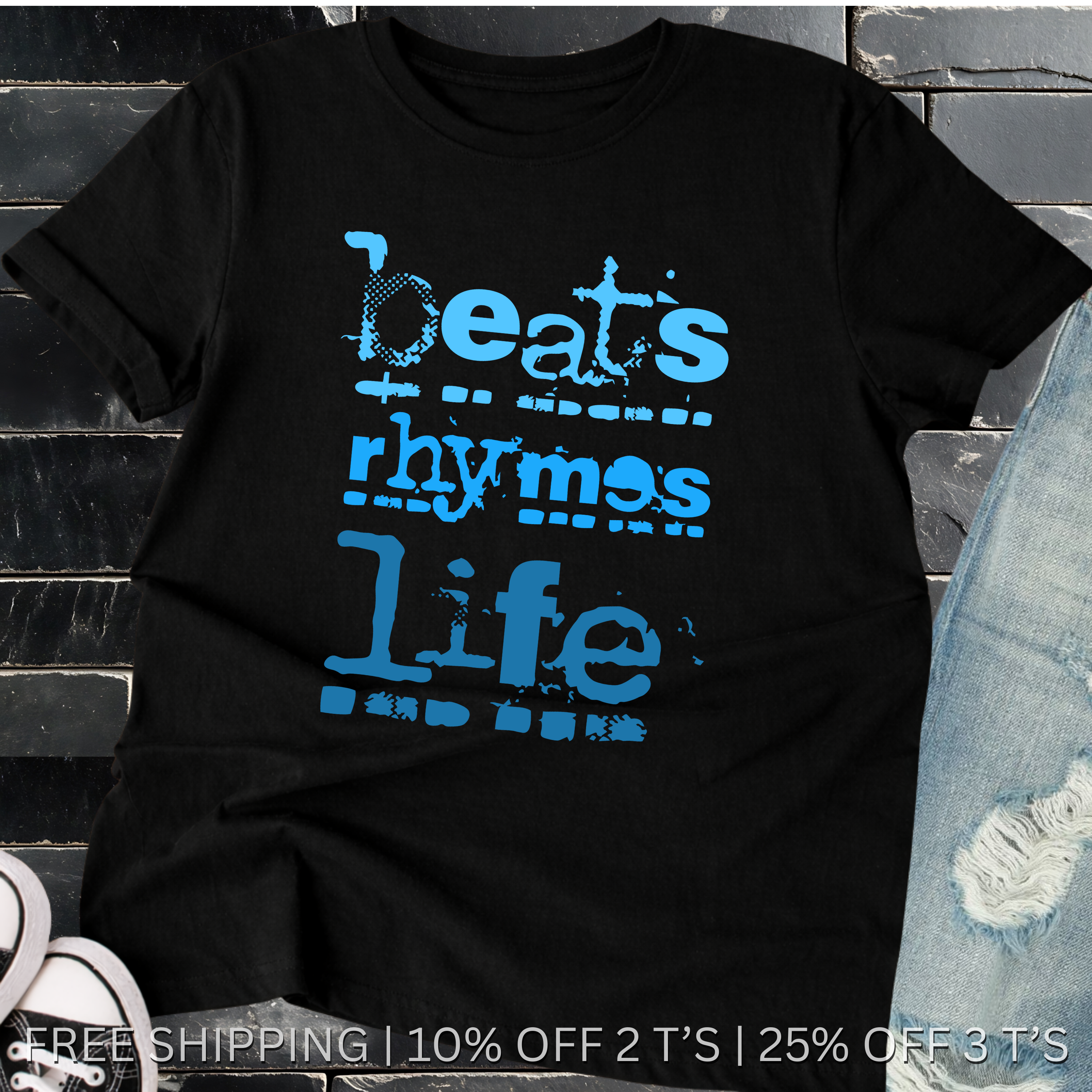 Black t-shirt with blue text 'beats rhymes life' on a stone surface.