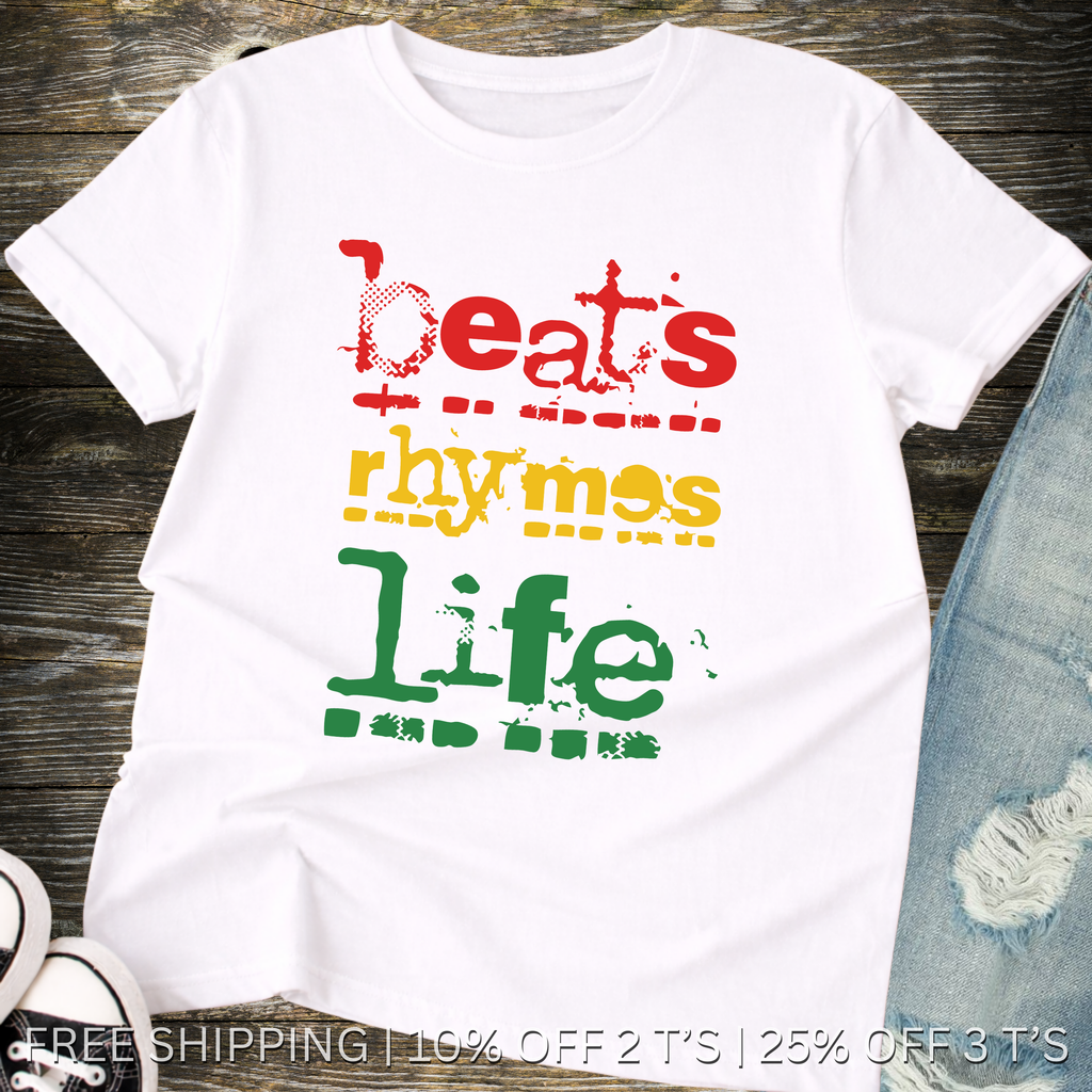 White t-shirt with colorful text 'Beats rhyme with life' on a wooden surface.