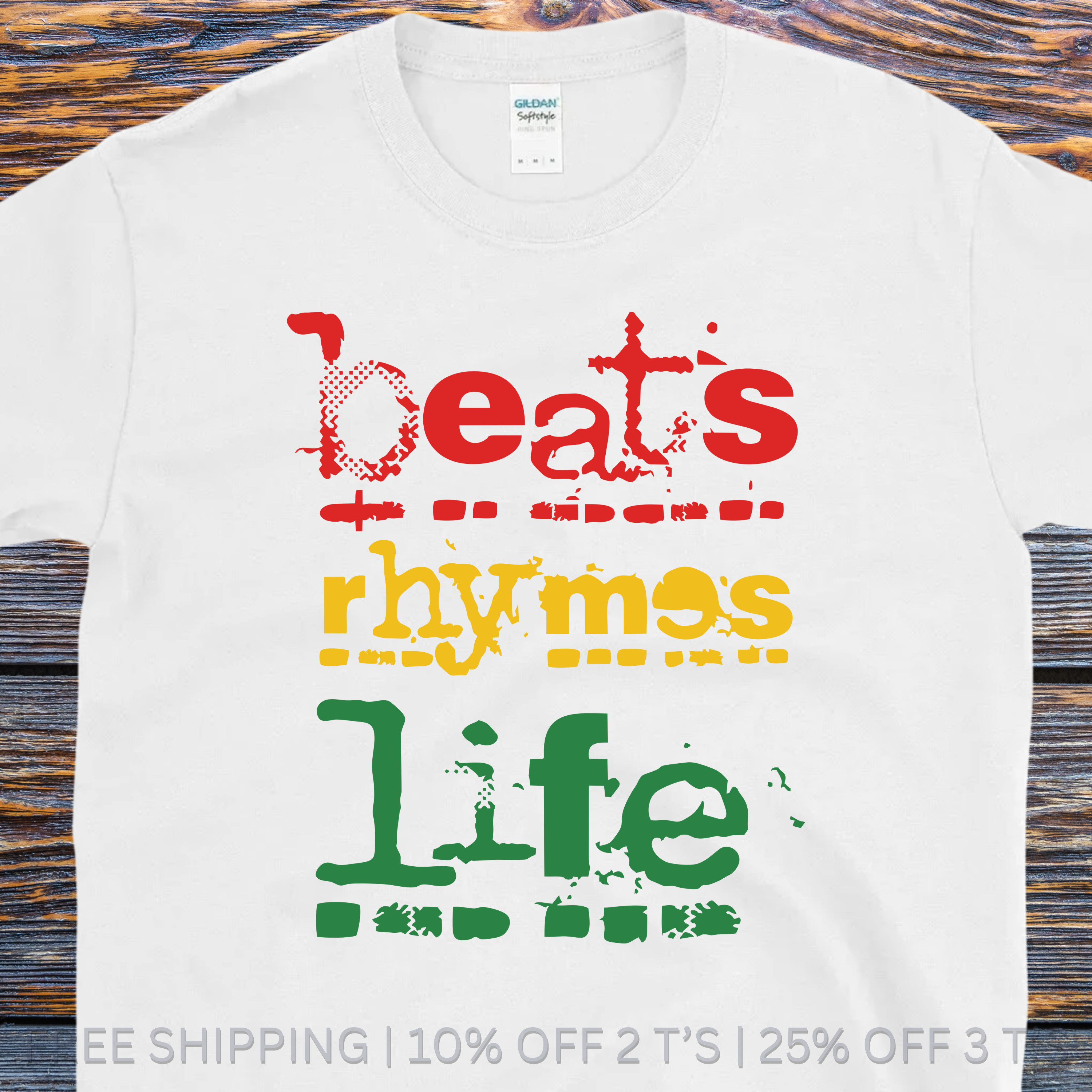 White t-shirt with colorful text 'beats rhymes life' on a wooden surface